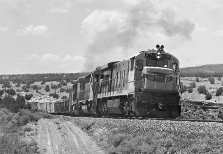 Eastbound Atchison, Topeka and Santa Fe Railway manifest freight train climbs through S-curve as it nears Scholle siding west of yard in Belen, New Mexico, in June 1985. Photograph by J. Parker Lamb, © 2017, Center for Railroad Photography and Art. Lamb-02-099-12