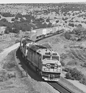 Eastbound Atchison, Topeka and Santa Fe Railway freight train climbs upgrade toward Scholle siding east of yard in Belen, New Mexico, in June 1985. Photograph by J. Parker Lamb, © 2017, Center for Railroad Photography and Art. Lamb-02-099-09