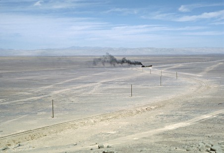 Against the Atacama Desert of northern Chile, steam locomotive no. 3511 and its four-car train appear as little more than a smudge on the landscape. Photograph by Fred M. Springer, © 2016, Center for Railroad Photography and Art. Springer-SOAM1-08-34