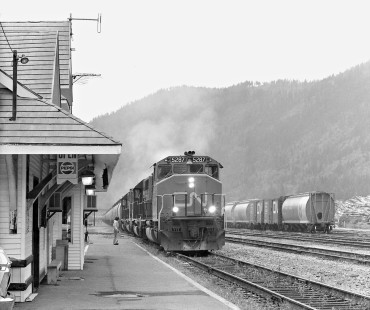 Eastbound Canadian National Railway empty grain train passes station in Boston Bar, British Columbia, in June 1978. Operator is trackside for inspection. Photograph by J. Parker Lamb, © 2017, Center for Railroad Photography and Art. Lamb-02-113-08