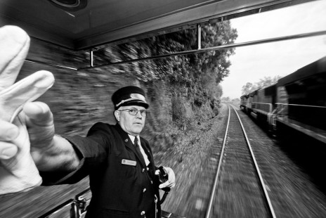 Union Pacific's Jim Coker has just wrapped up some business on the radio as his train passes an auto train going the opposite direction on June 2, 2011, during a trip behind steam locomotive no. 844. The photographer took the image from inside the passenger compartment through the door under employee supervision.