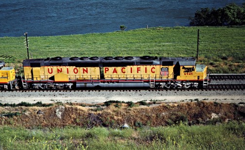 Westbound Union Pacific Railroad freight train led by DDA40X "Centennial" locomotive no. 6945 along Snake River in Glenns Ferry, Idaho, on June 29, 1984. Photograph by John F. Bjorklund, © 2016, Center for Railroad Photography and Art. Bjorklund-90-12-17