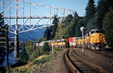 Westbound Union Pacific Railroad freight trains passing under the Bridge of the Gods along the Columbia River in Cascade Locks, Oregon, on September 14, 1991. Photograph by John F. Bjorklund, © 2016, Center for Railroad Photography and Art. Bjorklund-91-29-15
