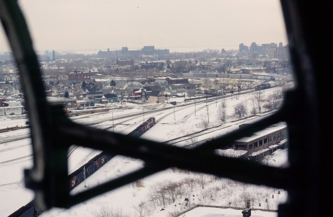 Photographer's notes: January 22, 1999, looking southwest from Buffalo Central Terminal's clock over Buffalo, New York, and frozen Lake Erie. The place was in ruins, the glass smashed out of the clock face. A Canadian National empty coal train waits to come off of the belt line as an eastbound Norfolk Southern mixed freight eases around the corner. Scan from Kodachrome 64, 35mm

Read more about the <a href="http://www.railphoto-art.org/awards/2016-awards/" rel="nofollow">2016 John E. Gruber Creative Photography Awards Program</a>.
