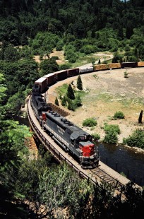 Westbound Southern Pacific Railroad freight train crossing Sacramento River at Cantara loop near Dunsmuir, California, on June 22, 1984. Photograph by John F. Bjorklund, © 2016, Center for Railroad Photography and Art. Bjorklund-86-21-13