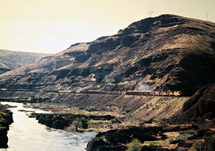 Northbound Union Pacific Railroad freight train along Deschutes River in Maupin, Oregon, on April 26, 1975. Photograph by John F. Bjorklund, © 2016, Center for Railroad Photography and Art. Bjorklund-89-14-14