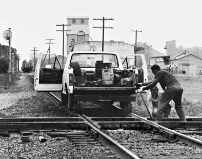 Missouri–Kansas–Texas Railroad track inspectors tighten bolts on Southern Pacific Railroad crossing at Elgin, Texas (east of Austin), in March 1973. Southbound local crew (background) is busy with switching chores. Photograph by J. Parker Lamb, © 2016, Center for Railroad Photography and Art. Lamb-02-045-05