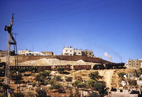 Hedjaz Jordan Railway 2-8-2 steam locomotive no. 51 moving along a hillside in Amman, Jordan, on July 17, 1991. Photograph by Fred M. Springer, © 2014, Center for Railroad Photography and Art. Springer-Hedjaz-ZimZam(1)-05-23
