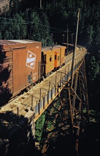 Caboose of westbound Milwaukee Road freight train crossing bridge in Hall Creek, Washington, on July 14, 1979. Photograph by John F. Bjorklund, © 2016, Center for Railroad Photography and Art. Bjorklund-68-11-12