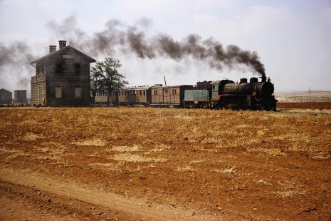 Syrian Railways 2-8-2 steam locomotive no. 263 pulls past a station in Bosra, Daraa, Syria on July 21, 1991. Photograph by Fred M. Springer, © 2014, Center for Railroad Photography and Art. Springer-Hedjaz-ZimZam(1)-12-07