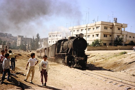 Hedjaz Jordan Railway 2-8-2 steam locomotive no. 71 travels alongside a group of children in Amman, Jordan, on July 15, 1991. Photograph by Fred M. Springer, © 2014, Center for Railroad Photography and Art. Springer-Hedjaz-ZimZam(1)-02-27