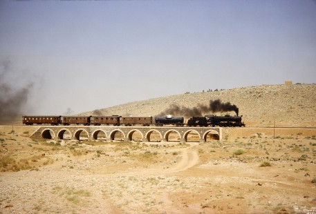 Hedjaz Jordan Railway 4-6-2 steam locomotive no. 82 carries a tank car and 4 passenger cars near Amman, Jordan, on July 16, 1991. Photograph by Fred M. Springer, © 2014, Center for Railroad Photography and Art.  Springer-Hedjaz-ZimZam(1)-04-14