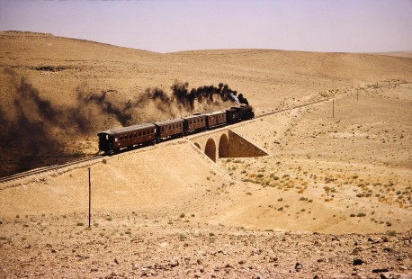 Hedjaz Jordan Railway and Syrian Railways 2-8-2 steam locomotive no. 51 across a short bridge in Petra, Ma'an, Jordan, on July 18, 1991. Photograph by Fred M. Springer, © 2014, Center for Railroad Photography and Art. Springer-Hedjaz-ZimZam(1)-06-30
