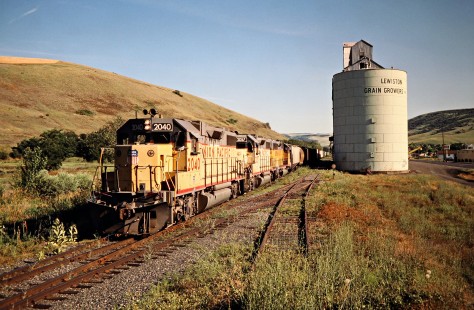 Westbound freight train on the Camas Prairie Railroad, owned and operated by Burlington Northern Railroad and Union Pacific Railroad, at Lapwai, Idaho, on July 1, 1988. Photograph by John F. Bjorklund, © 2016, Center for Railroad Photography and Art. Bjorklund-93-16-21