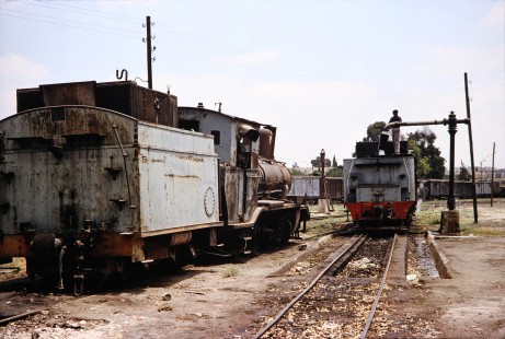 Two Syrian Railways steam locomotives wait on servicing tracks as a worker fills one of their tenders with water in Daraa, Daraa, Syria on July 19, 1991. Photograph by Fred M. Springer, © 2014, Center for Railroad Photography and Art. Springer-Hedjaz-ZimZam(1)-08-38