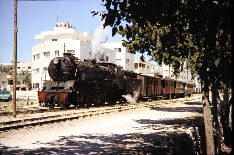 Hedjaz Jordan Railway 2-8-2 steam locomotive no. 51 travels through a village near Amman, Jordan, on July 17, 1991. Photograph by Fred M. Springer, © 2014, Center for Railroad Photography and Art.Springer-Hedjaz-ZimZam(1)-05-09