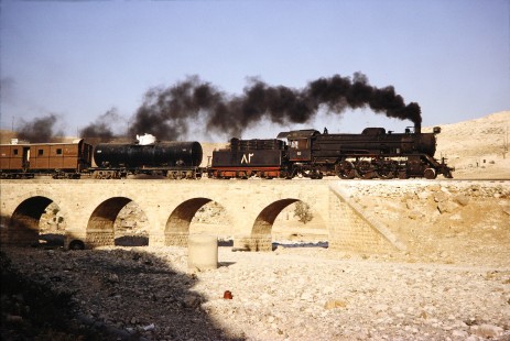 Hedjaz Jordan Railway steam locomotive no. 82 crosses a small bridge in Amman, Jordan, on July 17, 1991. Photograph by Fred M. Springer, © 2014, Center for Railroad Photography and Art. Springer-Hedjaz-ZimZam(1)-05-30