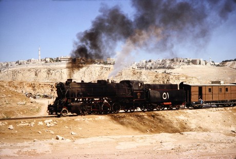 Hedjaz Jordan Railway 2-8-2 steam locomotive no. 51 travels amongst outskirts of the city in Amman, Jordan, on July 17, 1991. Photograph by Fred M. Springer, © 2014, Center for Railroad Photography and Art. Springer-Hedjaz-ZimZam(1)-05-12