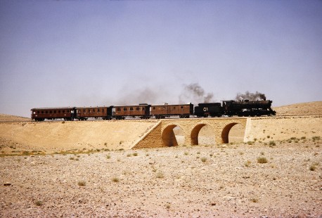 Hedjaz Jordan Railway and Syrian Railways 2-8-2 steam locomotive no. 51 with 4 passenger cars in Petra, Ma'an, Jordan, on July 18, 1991. Photograph by Fred M. Springer, © 2014, Center for Railroad Photography and Art. Springer-Hedjaz-ZimZam(1)-06-27