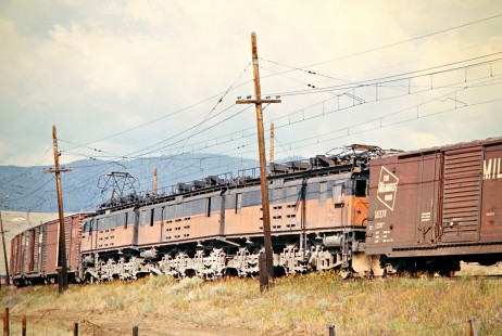 Westbound Milwaukee Road freight train with "boxcab" electric locomotives operating as mid-train helpers in Butte, Montana, on July 21, 1973. Photograph by John F. Bjorklund, © 2016, Center for Railroad Photography and Art. Bjorklund-64-04-19