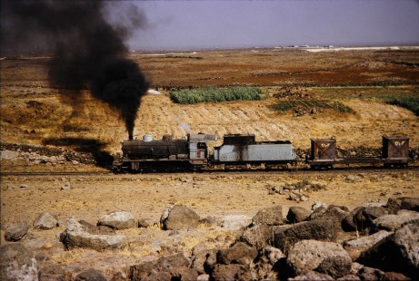 Syrian Railways steam locomotive no. 162 passes through an open field in Daraa, Daraa, Syria on July 19, 1991. Photograph by Fred M. Springer, © 2014, Center for Railroad Photography and Art. Springer-Hedjaz-ZimZam(1)-08-17