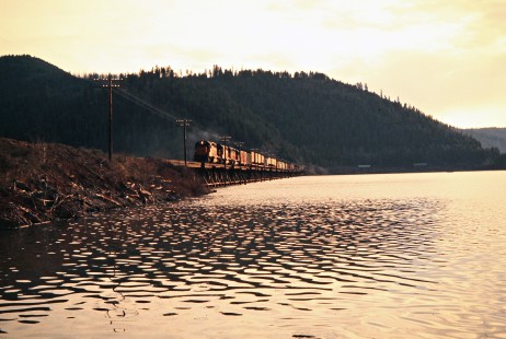 Eastbound Milwaukee Road freight train at Benewah Lake, Idaho, on April 29, 1975. Photograph by John F. Bjorklund, © 2016, Center for Railroad Photography and Art.  Bjorklund-64-21-04