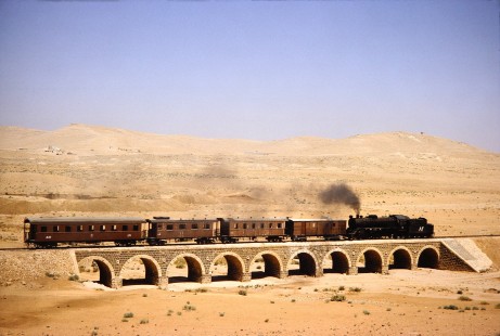 Hedjaz Jordan Railway 4-6-2 steam locomotive no. 82 pulls 4 passenger cars in the desert near Amman, Jordan, on July 16, 1991. Photograph by Fred M. Springer, © 2014, Center for Railroad Photography and Art. Springer-Hedjaz-ZimZam(1)-04-30