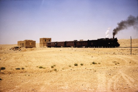Hedjaz Jordan Railway and Syrian Railways 2-8-2 steam locomotive no. 51 departs from a small station in Petra, Ma'an, Jordan, on July 18, 1991. Photograph by Fred M. Springer, © 2014, Center for Railroad Photography and Art. Springer-Hedjaz-ZimZam(1)-06-36