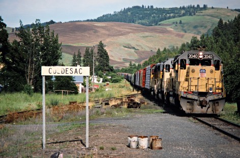 Westbound Camas Prairie Railroad freight train, owned and operated by Burlington Northern Railroad and Union Pacific Railroad, at Culdesac, Idaho, on July 1, 1988. Photograph by John F. Bjorklund, © 2016, Center for Railroad Photography and Art. Bjorklund-93-17-18