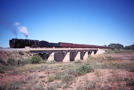 South African Railway 4-8-4 steam locomotive no. 3410 stops with its passenger cars along a bridge on the Riet River in Bloemfontein, Free State, South Africa, on March 31, 1995. Photograph by Fred M. Springer, © 2014, Center for Railroad Photography and Art. Springer-So.Africa-NOR-SWE-03-40