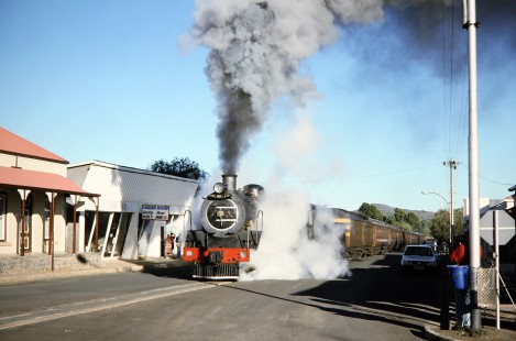 South African Railway 4-8-2 steam locomotive no. 2649 or "Anna" passes by both onlookers and the Fauresmith Meatmarket in Fauresmith, Free State, South Africa, on March 31, 1995. Photograph by Fred M. Springer, © 2014, Center for Railroad Photography and Art. Springer-So.Africa-NOR-SWE-02-19