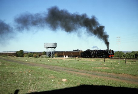 South African Railway 4-8-2 steam locomotive no. 3300 or "Mandy" carries a long train of passenger cars in Kloofeind, Free State, South Africa, on March 31, 1995. Photograph by Fred M. Springer, © 2014, Center for Railroad Photography and Art. Springer-So.Africa-NOR-SWE-03-20