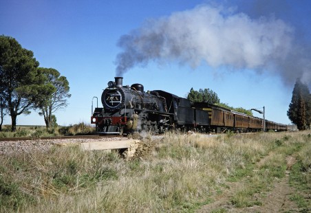 South African Railway 4-8-2 steam locomotive no. 2649 or "Anna" pulls a lengthy passenger train in Philippolis, Free State, South Africa, on March 31, 1995. Photograph by Fred M. Springer, © 2014, Center for Railroad Photography and Art. Springer-So.Africa-NOR-SWE-02-04