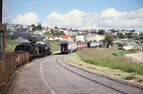 South African Railway 4-8-0 steam locomotives nos. 1007 and 1056  tread along a curved bend in the track in Mossel Bay, Western Cape, South Africa, on March 21, 1995. Photograph by Fred M. Springer, © 2014, Center for Railroad Photography and Art. Springer-So.Africa(1)-12-04