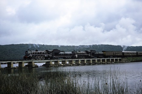 South African Railway steam locomotives carry a train of passenger cars over the Swartvlei Bridge in Sedgefield, Western Cape, South Africa, on March 22, 1995. Photograph by Fred M. Springer, © 2014, Center for Railroad Photography and Art. Springer-So.Africa(1)-15-21