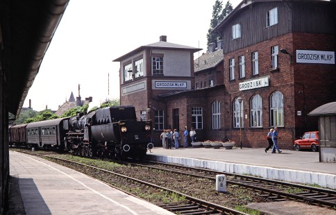 Polskie Koleje Państwowe (Polish State Railways) 2-10-0 steam locomotive no. Ty42-148 pulls in next to a platform at Grodzisk Wielkopolski station in Grodzisk, Greater Poland, Poland, on May 20, 1993. Photograph by Fred M. Springer, © 2014, Center for Railroad Photography and Art. Springer-Europe-01-08