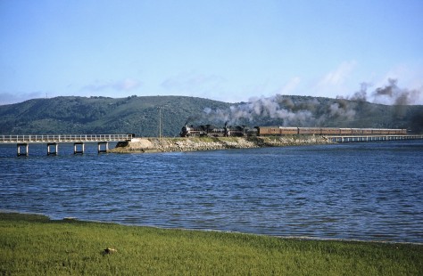 South African Railway steam locomotive cross the island of the Knysna Lagoon bridge in Knysna, Western Cape, South Africa, on March 22, 1995. Photograph by Fred M. Springer, © 2014, Center for Railroad Photography and Art. Springer-So.Africa(1)-16-36