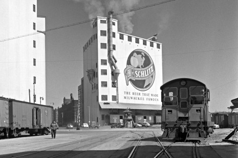Milwaukee Road Fairbanks-Morse H-12-44 diesel switcher at the Schlitz Brewery on the railroad's "Beer Line" in Milwaukee, Wisconsin, in 1952. West Cherry and North Second streets both cross the tracks just behind the locomotive. Abbey-01-084-02