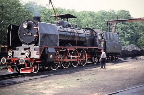 Polskie Koleje Państwowe  (Polish State Railways) 2-8-2 steam locomotive no. Pt47-65 waits as a worker inspects it in Wolsztyn, Greater Poland, Poland, on May 20, 1993. Photograph by Fred M. Springer, © 2014, Center for Railroad Photography and Art. Springer-Europe-02-25