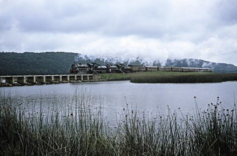 South African Railway steam locomotives carry a train of passenger cars over the Swartvlei Bridge in Sedgefield, Western Cape, South Africa, on March 22, 1995. Photograph by Fred M. Springer, © 2014, Center for Railroad Photography and Art. Springer-So.Africa(1)-15-22