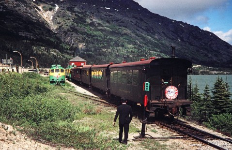 Two White Pass and Yukon Route passenger trains pass one another as the conductor of one train watches in Fraser, British Columbia, Canada, on June 12, 1998. Photograph by Fred M. Springer, © 2014, Center for Railroad Photography and Art. Springer-Alaska-NZ-09-23