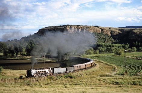South African 4-8-4 steam locomotive no. 3410 pulls a long passenger train around a curve amongst the farmland in Ficksburg, Free State, South Africa, on March 26, 1995. Photograph by Fred M. Springer, © 2014, Center for Railroad Photography and Art. Springer-So.Africa(1)-21-16