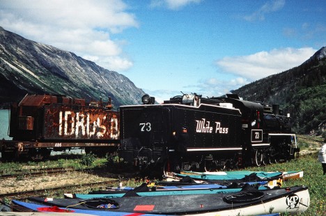 An older, rusted car and many kayaks sit alongside White Pass and Yukon Route tracks next to steam locomotive no. 73 in Bennett, British Columbia, Canada, on June 13, 1998. Photograph by Fred M. Springer, © 2014, Center for Railroad Photography and Art. Springer-Alaska-NZ-11-33