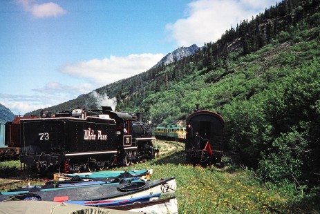 Two tracks come together showing both the diesel and steam locomotives (no. 73) used by the White Pass and Yukon Route railway. An array of kayaks sit to the side of the tracks in Bennett, British Columbia, Canada, on June 13, 1998. Photograph by Fred M. Springer, © 2014, Center for Railroad Photography and Art. Springer-Alaska-NZ-11-29