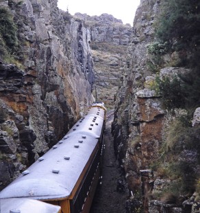 A Taieri Gorge Railway diesel locomotive and passenger train inside a narrow rock cut in Dunedin, Otago, New Zealand, on January 19, 1994. Photograph by Fred M. Springer, © 2014, Center for Railroad Photography and Art. Springer-NZ(1)-16-12