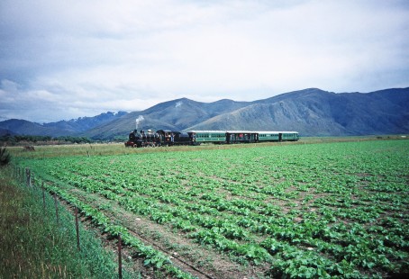 Glenbrook Vintage Railway steam locomotive no. 778 travels past the mountains and farmlands of Milford Sound in Fairlight, Southland, New Zealand, on January 13, 1996. Photograph by Fred M. Springer, © 2014, Center for Railroad Photography and Art. Springer-NZ(2)-12-03