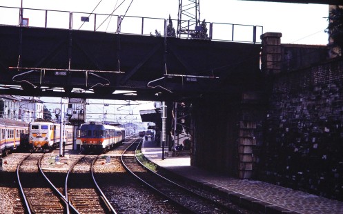 Two trains approach to pass under a street bridge in Lecco, Lombardy, Italy, on July 9, 1989. Photograph by Fred M. Springer, © 2014, Center for Railroad Photography and Art. Springer-Scan-Swiss-York-16-08