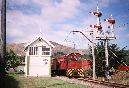 Diesel locomotive no. 156 proceeds past a signal tower with semaphores in Christchurch, Canterbury, New Zealand, on January 14, 2006.   Photograph by Fred M. Springer, © 2014, Center for Railroad Photography and Art. Springer-Alaska-NZ-21-36