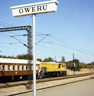 A close-up shot of the the Gweru platform sign with a National Railways of Zimbabwe locomotive pulling to a stop in Gweru, Zimbabwe, on July 28, 1991. This is a city stop on the Bulawayo to Harare train Line. Photograph by Fred M. Springer, © 2014, Center for Railroad Photography and Art. Springer-Hedjaz-ZimZam(1)-14-06
