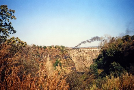 Garratt steam locomotive crosses the Victoria Falls Bridge between Livingstone, Zambia and Victoria Falls, Zimbabwe, on August 7, 1991. Photograph by Fred M. Springer, © 2014, Center for Railroad Photography and Art. Springer-ZimZam(2)-Swiss-19-09